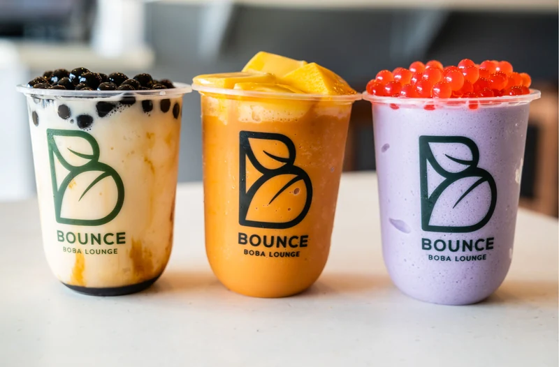 Tres bebidas coloridas de boba listas para compartir en Bounce Boba Lounge