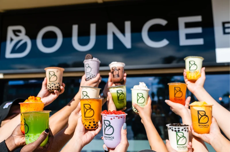 Clientes sosteniendo bebidas coloridas de Bounce Boba Lounge afuera de la tienda de Northridge