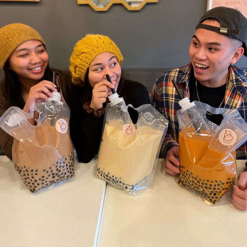 Amigos sosteniendo Party Packs de Bounce Boba Lounge